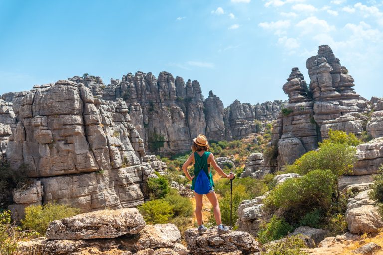 back-view-of-a-woman-standing-on-the-rock-and-looking-at-the-landscape-of-torcal-de-antequera