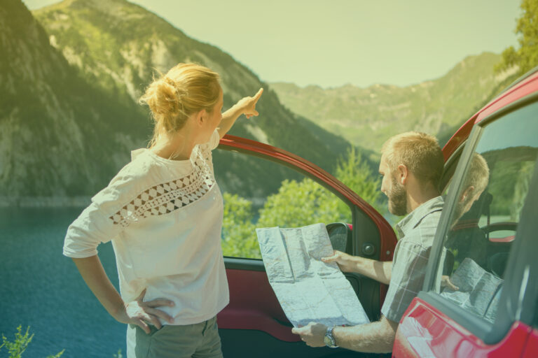 young-couple-on-road-trip-reading-a-map-for-directions-summer-5