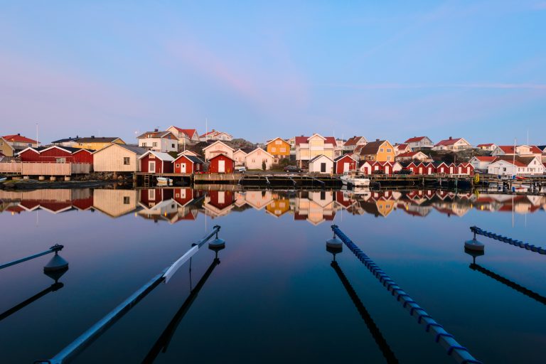 colorful-houses-reflecting-in-a-calm-harbor-on-the-west-coast-of-sweden-during-sunset-2