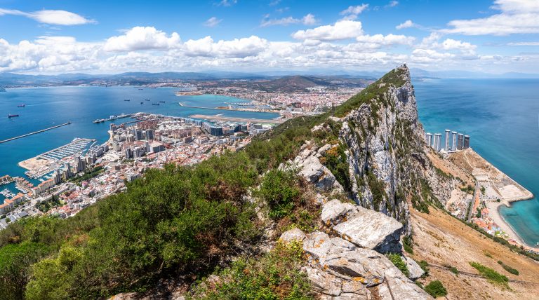 breathtaking-panoramic-view-of-gibraltar-featuring-the-iconic-rock-bustling-city-harbor-filled-with-ships-airport-and-stunning-coastline-under-blue-skies-and-white-clouds-2